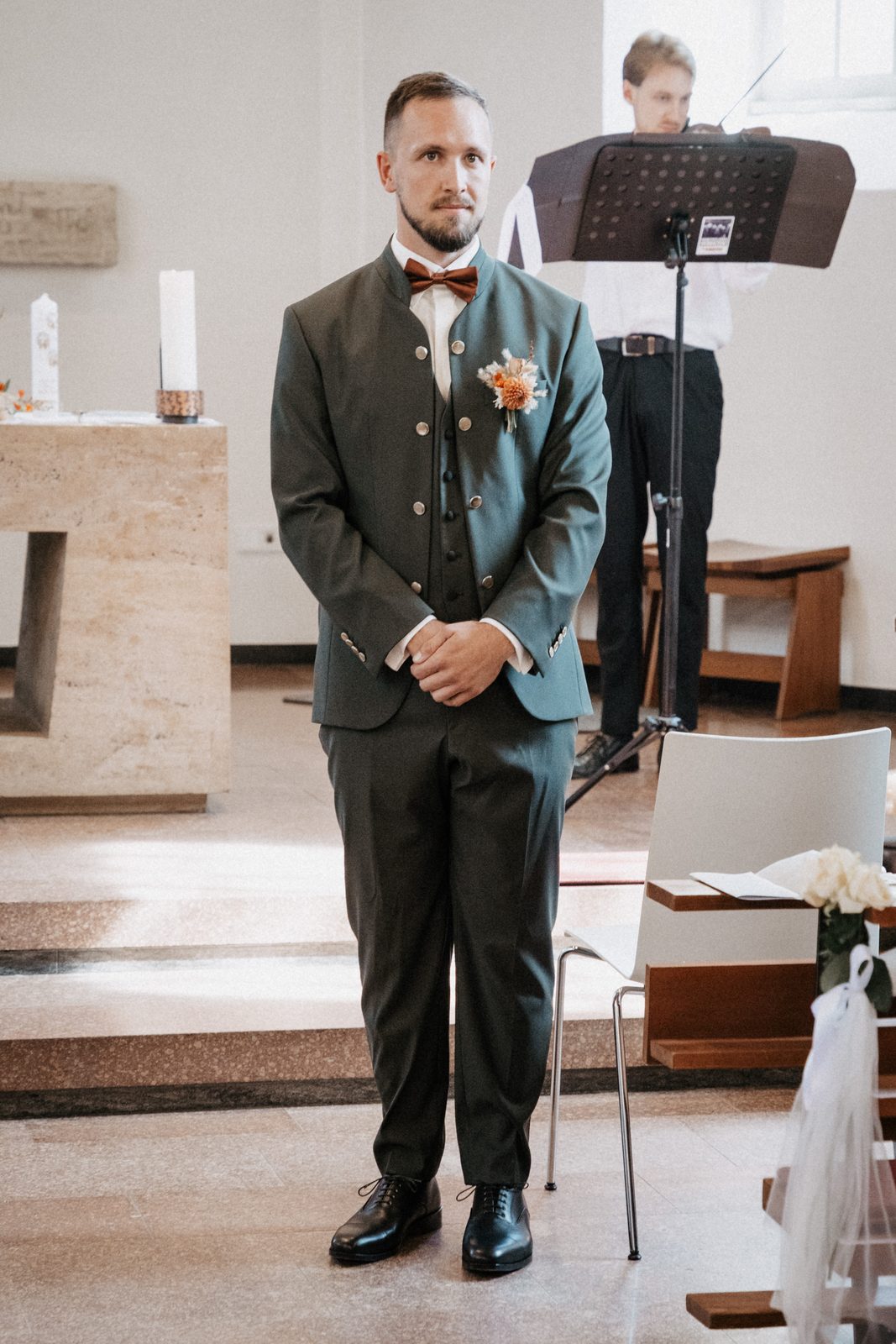 Bräutigam steht vorn in der Kirche und wartet auf den Einzug der Braut