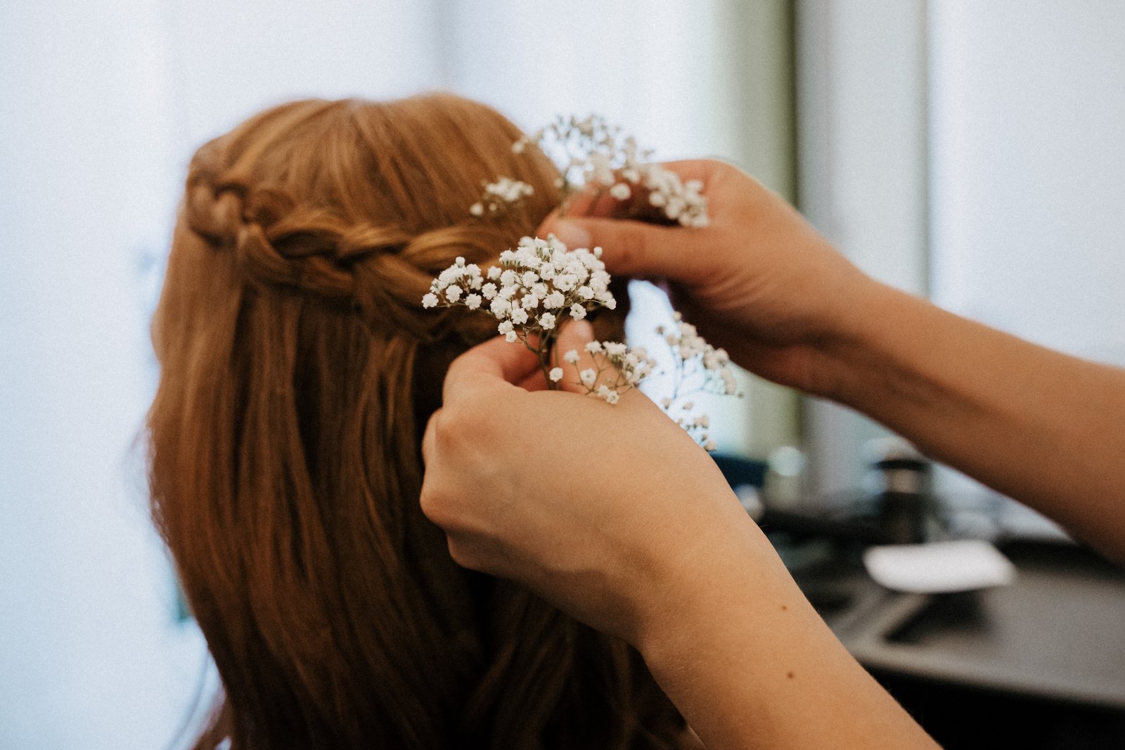 Braut beim Getting Ready, Blumen werden ins Haar gesteckt