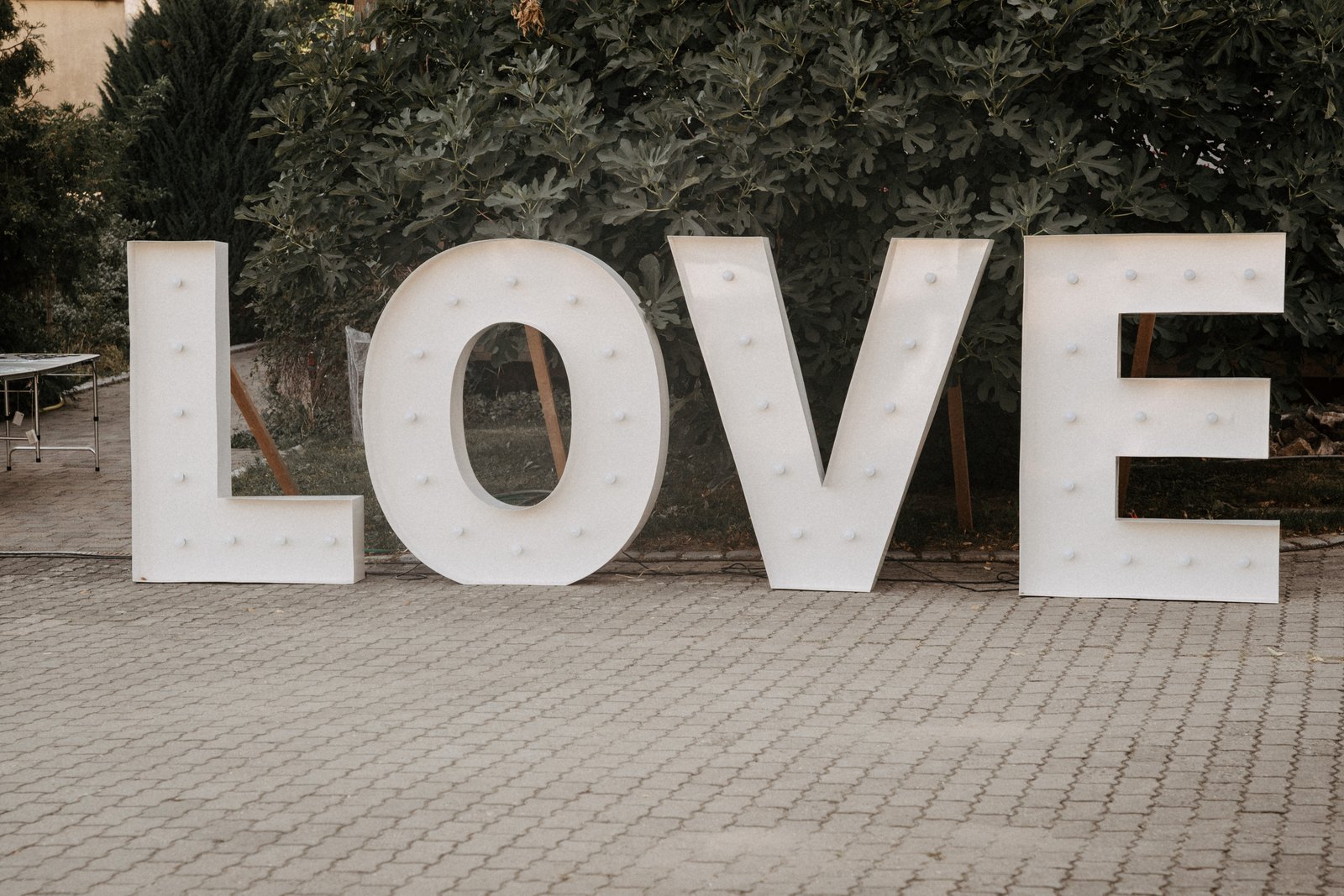 Große beleuchtete LOVE-Buchstaben als Hochzeitsdeko im Hof, aufgebaut am frühen Morgen