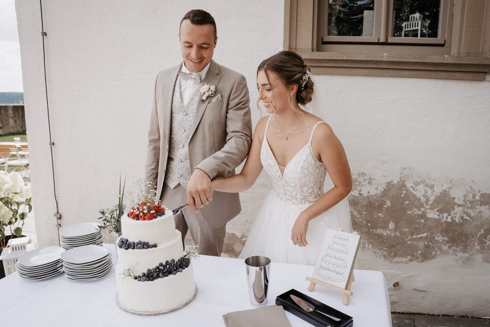 Brautpaar schneidet die Hochzeitstorte im Saal an