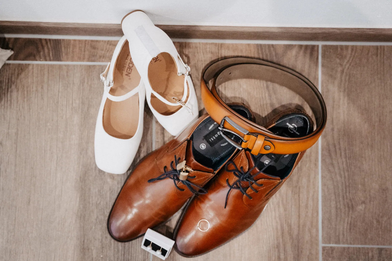 Brautschuhe, Herrenschuhe und ein Ledergürtel als Detailaufnahme vor der Hochzeit