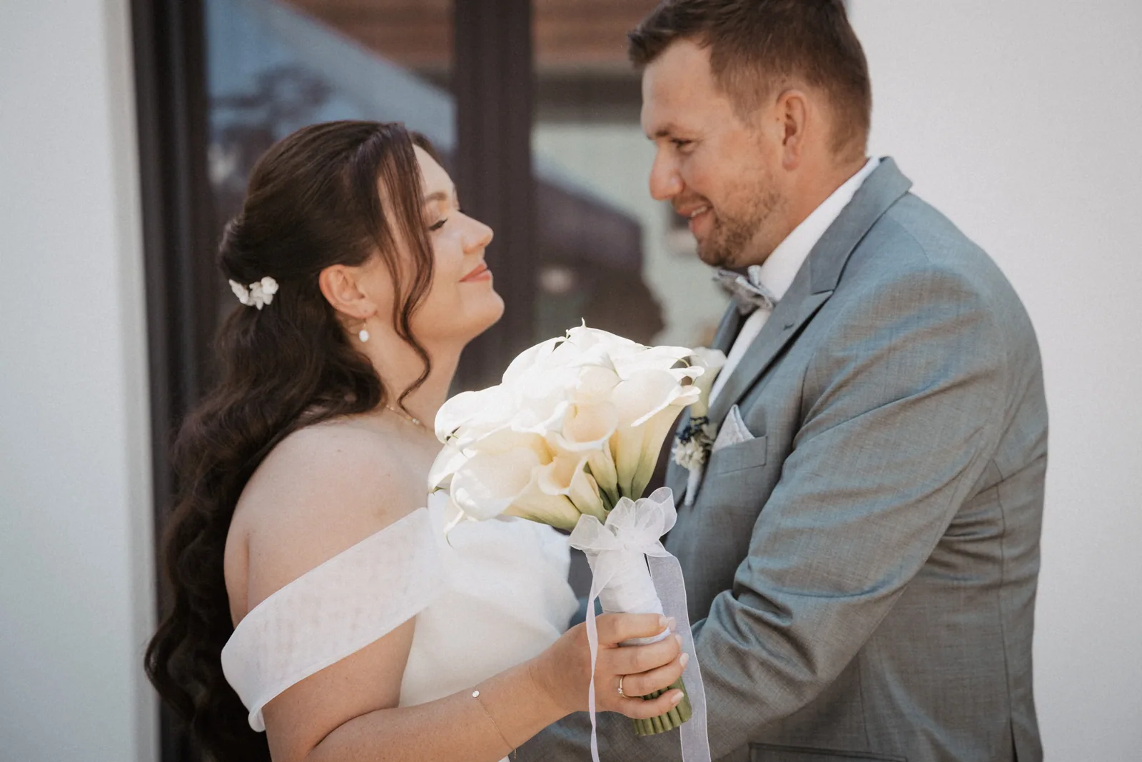 First Look im Hof in Gattenhofen, die Braut lacht den Bräutigam an