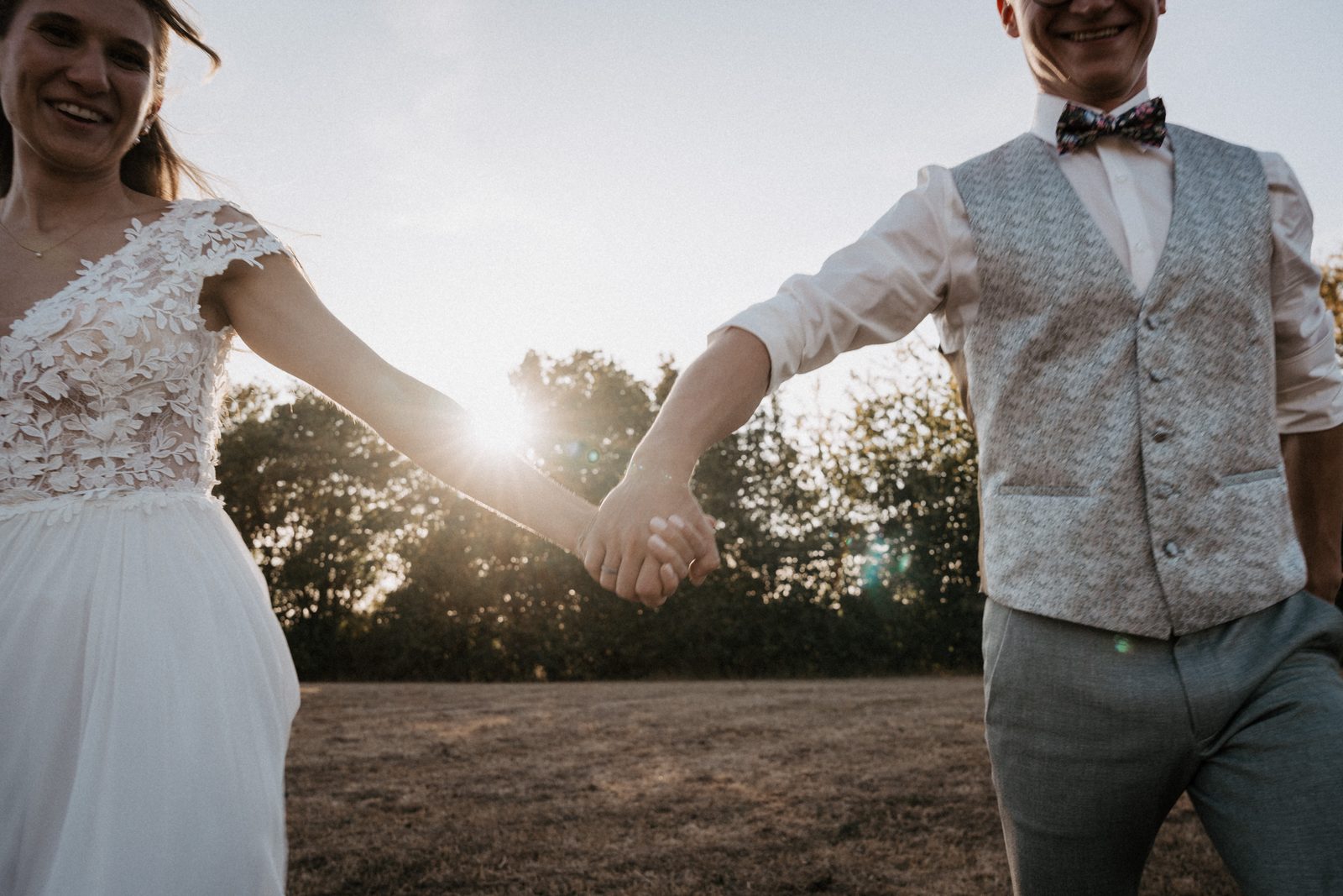 Brautpaar Hand in Hand, die Abendsonne steht genau zwischen beiden, bei Oberaltertheim