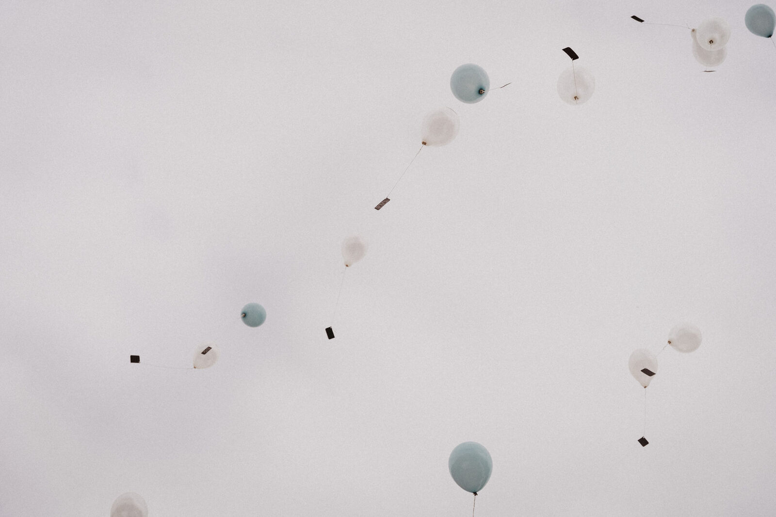 Luftballons steigen in den grauen Himmel
