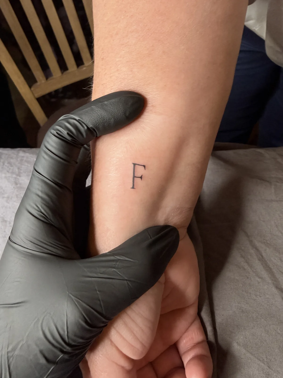 Hochzeitstattoo mit einem einzelnen Buchstaben auf dem Unterarm