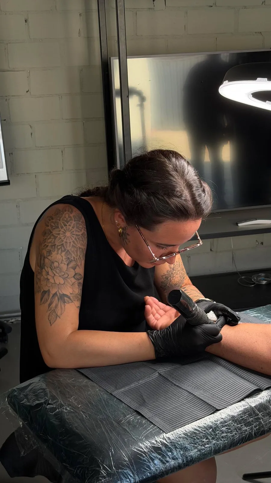 Tattoo-Station auf der Hochzeit, Tätowiererin Jessi von Love Ink sticht ein Mini-Tattoo