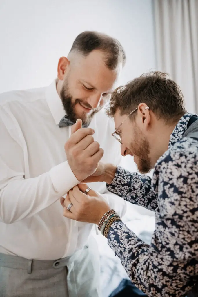 Bruder des Bräutigam hilft, Bräutigam beim Schließen der Manschettenknöpfe beim Getting ready