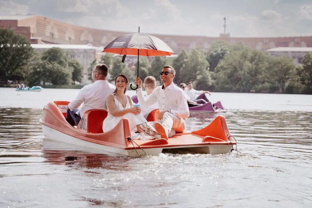 Brautentführung auf dem Dutzendteich in Nürnberg, Braut wird lachend auf ein Trettboot enführt